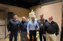 Group photo including (left to right) Jose Villarreal, Jeff Betzoldt, Doug Adams, Mike Sausman, and Tom Cain with Doug holding his engraved crystal leadership award
